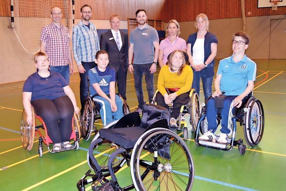 Über einen neuen Sportrollstuhl freut sich die Jugendrollstuhlgruppe der RBSG um ihren 2. Vorsitzenden Andreas Maempel (l.) und den ausgebildeten Therapeutinnen Anke Scholwin (hinten, r.) und Sandra Sahner. Sparkassen-Filialleiter Olaf Nelle (hinten, 3.v.l.) sowie die Brüder Alfred (hinten, 2.v.l.) und Kay Klindwort übergaben das hochwertige Sportgerät. (Foto: René Kleinschmidt)
