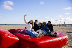 Eine Familie erkundet die Riesenwärmflasche am Ostseestrand. (Foto: www.ostsee-schleswig-holstein.de)