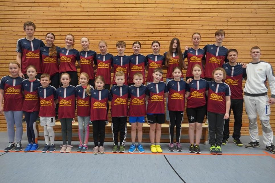 Die jungen Leichtathleten in den neuen Aufwärmshirts mit Sponsor Alex Hansmann (re.)