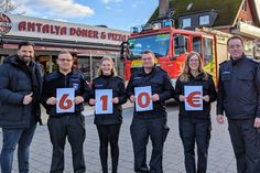 Ufuk Ilgen (lks.) bei der symbolischen Spendenübergabe an die Kinder- und Jugendfeuerwehr Grömitz.