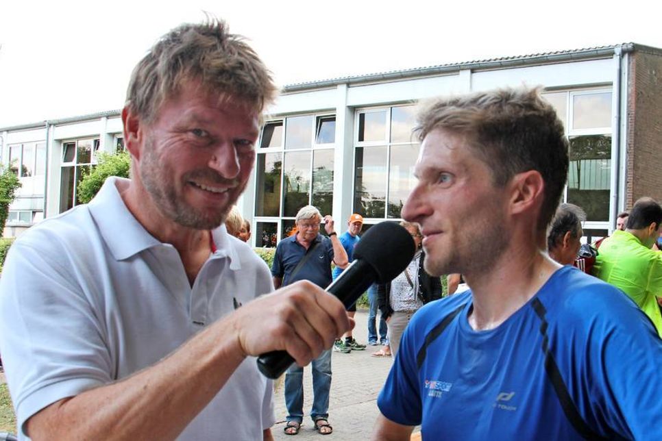 Sportmoderator Andreas Kling im Gespräch mit dem Sieger des Halbmarathons Dennis Mehlfeld vom Lübecker SC.