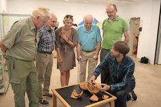 Stellten ihre Exponate zur Verfügung: Peter Seehusen (lks.), Rolf Seidel (2. v. lks.), Peter Rehder (2. v. re.) und Gerhard Kaiser (re.). Die Ausstellung wurde eröffnet von Dr. Katharina Schlüter (stehend Mitte), Geschäftsführerin der Sparkassen-Kulturstifung Ostholstein und Kurator Boris Breske (kniend re.).