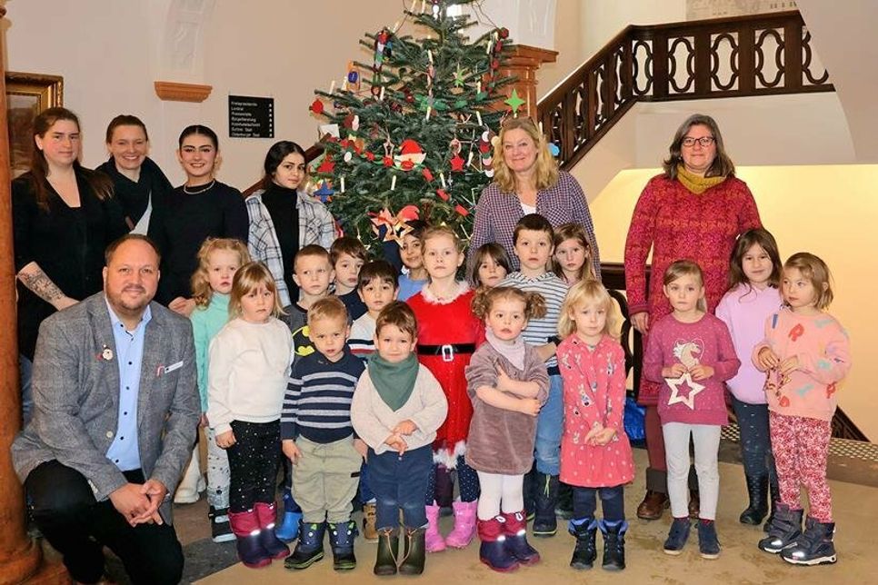 Landrat Gaarz und die Kinder und Erzieherinnen der Kitas Seerose und Ostseekinder schmücken die Tannenbäume im Kreishaus.