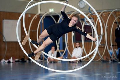 Torva Franz in der Spirale. Das Rhönrad bewegt sich dreidimensional auf einem Reifen und wird mit Schwung des Körpers in Bewegung gehalten.