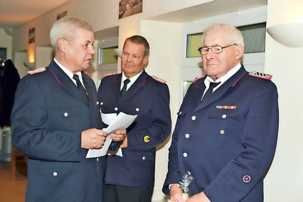 Sohn ehrt Vater: Wehrführer Carsten Dede überreicht Urkunde und Präsent an Heinrich Dede für 60 Jahre Mitgliedschaft, im Hintergrund Gemeindewehrführer Stephan Muss. (Foto: René Kleinschmidt)