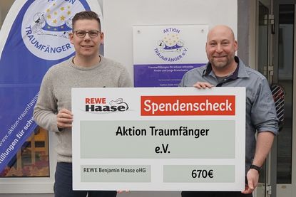 Kevin Pirsig (lks.), Vorstandsvorsitzender der „Aktion Traumfänger“ nimmt mit Freude den Spendenscheck von Patrick Bieber von Rewe Haase entgegen.