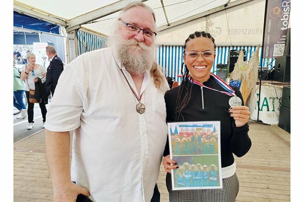 Aalritter Jürgen Brede mit der neuen Aalritterin Aminata Belli. Stolz hält sie ihren Aalritterorden und zwei Fotos von 2000 und 2001 in ihren Händen, als sie noch als kleine Nixe dabei war.