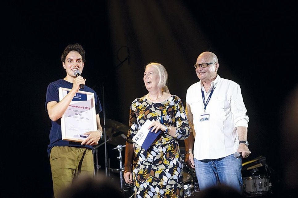 Übergabe des IB.SH-JazzAwards an Ilja Ruf (links) durch Gabriela Albertsen und Nils Landgren.