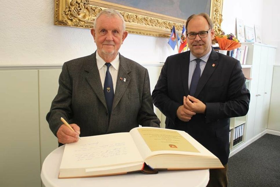 Ein feierlicher Moment. Heiner Evers (lks.) im Beisein von Bürgermeister Mirko Spieckermann beim Eintrag ins Goldene Buch der Stadt Neustadt.