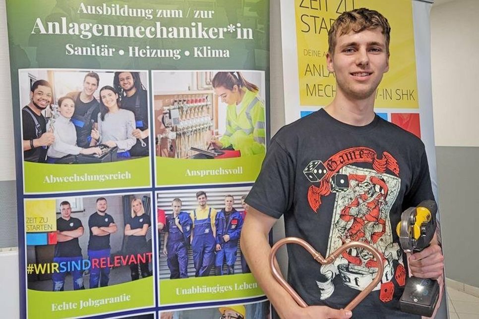 Der Auszubildene Malte Bensien presst als angehender Anlagenmechaniker Rohre zu einem Herzen zusammen