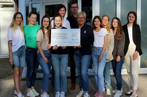 Ein Foto vor dem Deutschunterricht mit der Geschäftsführung und dem symbolischen Scheck der Spendenaktion. Im Anschluss haben die Mädchen ihren ersten Deutschtest geschrieben.