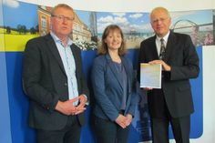 Landrat des Kreises Ostholstein, Reinhard Sager (re.), nimmt den Förderbescheid entgegen, zusammen mit Sybille Kiemstedt (Fachdienstleiterin des Fachdienstes Regionale Planung) und Nils Hollerbach (Fachbereichsleiter des Fachbereiches Planung, Bau und Umwelt).