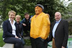 Der „Reisende“ in greller Kapuzenjacke auf der Aussichtsterrasse des Paasch-Eyler-Platzes, umrahmt von Claudia Reshöft, 2. Vorsitzende Landkunststück, Kirsten Sköries, Vorsitzende des Tourismusausschusses, Bildwerker Johannes Caspersen und Bürgermeister Volkert Stoldt.