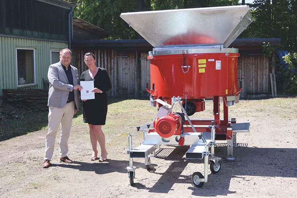 Ostholsteins Landrat Timo Gaarz und die Scharbeutzer Bürgermeisterin Bettina Schäfer im Frühjahr bei der Übergabe der Sandsackfüllmaschine.