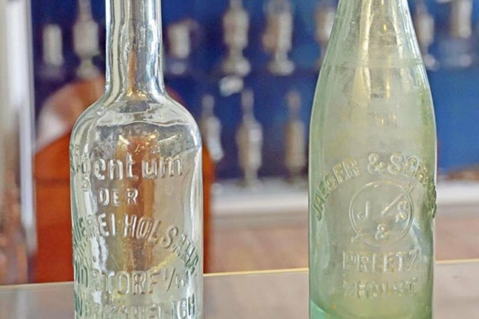 Diese transparente Glasflasche (rechts) wurde um 1900 in der Preetzer Berg-Brauerei Jaeger &amp;amp; Schmidt befüllt. Das Unternehmen existierte von 1892 bis 1952 Am Schützenplatz.