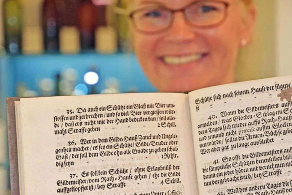 Museumsleiterin Julia Meyer präsentiert die Plöner „Schützen-Ordnung“, die einige Erkenntnisse rund ums Bier preisgibt.