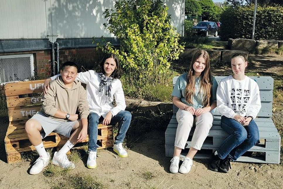 Die Neuntklässler Idris (von links), Gabriele Riccardo, Paulina-Sophie und Mia sitzen schon einmal Probe auf ihren gebauten Palettenmöbeln.
