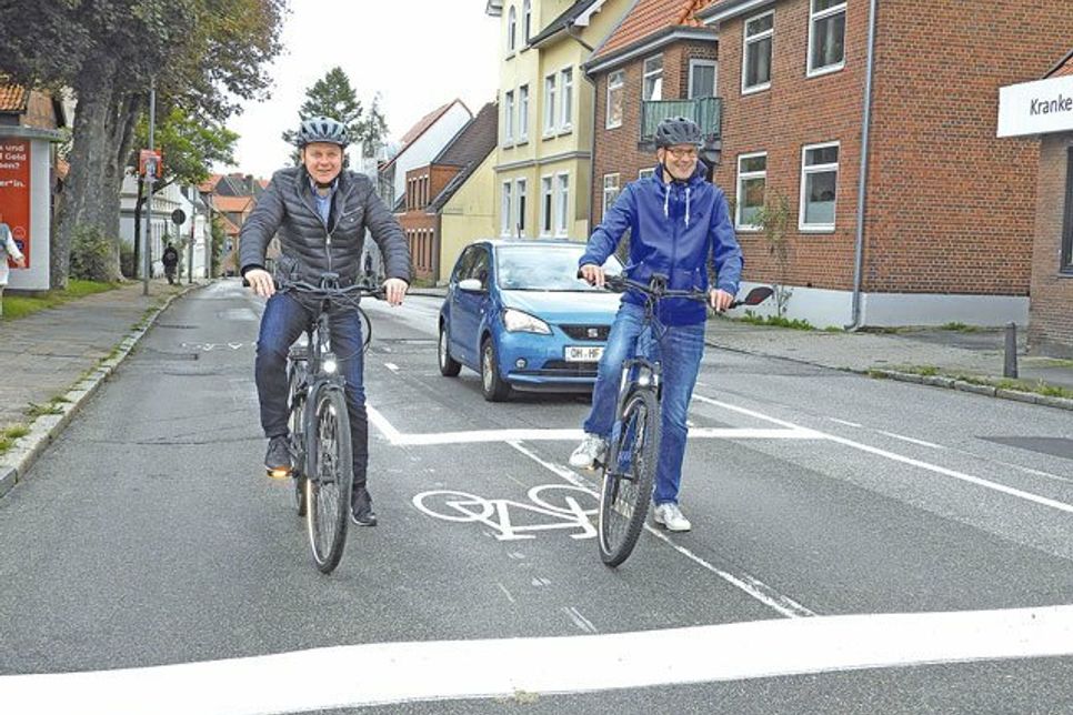 So ist es richtig: Bürgermeister Carsten Behnk und Timo Hantel (Öffentliche Sicherheit) zeigen in der Weidestraße, wie es geht mit den ARAS. Und das Fahrzeug im Hintergrund steht vorschriftsmäßig.
