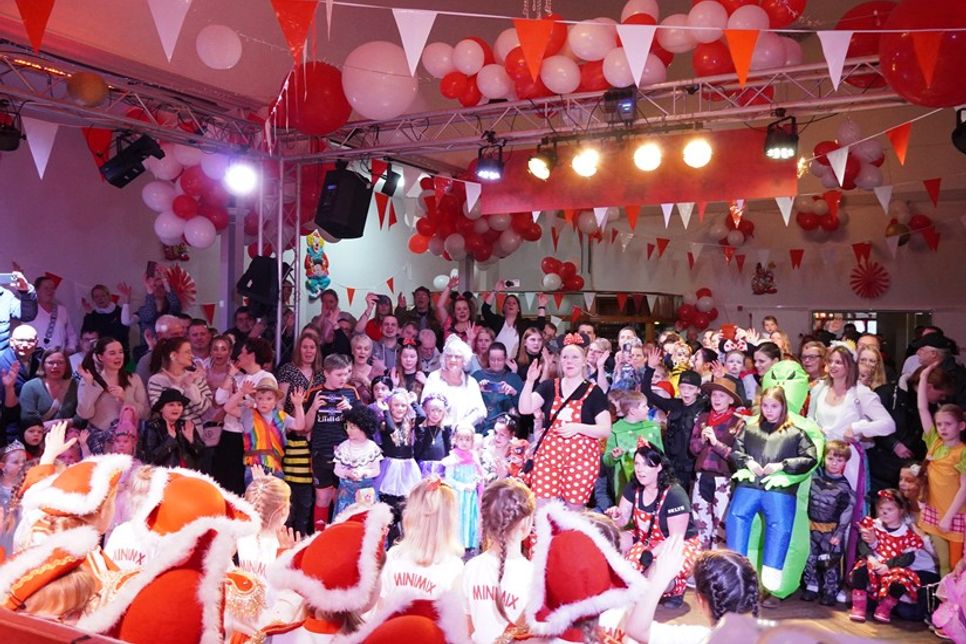 Karnevalsfans feiern ausgelassen den Karneval am Lachsbach in Schönwalde.