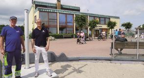 Tourismusleiter Thorsten Dücker (re.) mit Bauhof-Mitarbeiter Michael Höppner vor einer der neuen Außenduschen. Im Hintergrund des Haus des Gastes, in dem ein Info-Point etabliert ist.
