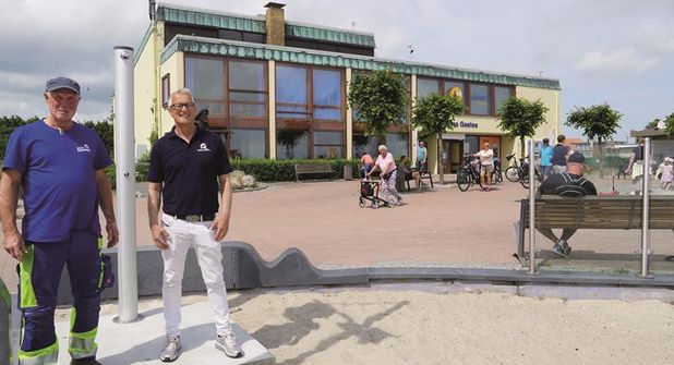 Tourismusleiter Thorsten Dücker (re.) mit Bauhof-Mitarbeiter Michael Höppner vor einer der neuen Außenduschen. Im Hintergrund des Haus des Gastes, in dem ein Info-Point etabliert ist.