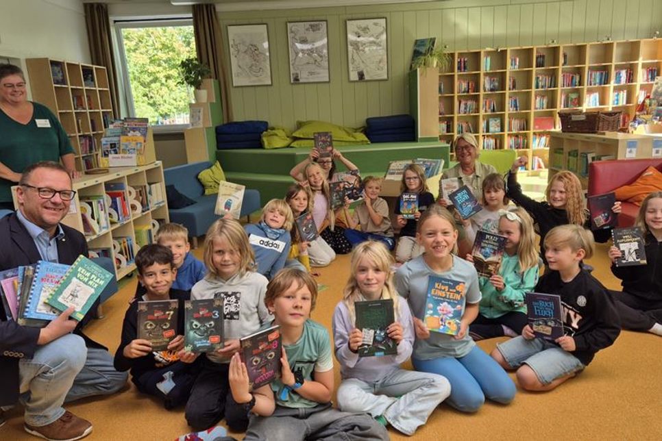 Große Freude über neue Bücher: Rotary-Präsident Thorsten Schmidt überreichte gemeinsam mit Schulleiterin Antje Sagawe den Kindern der Klasse 3f eine Spende für den Bücherhafen der Grundschule Neustädter Bucht.