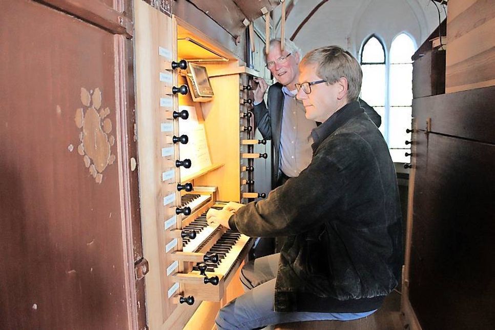 Organist Andreas Brunion (re.) bedankte sich mit einem „Ständchen“ bei Uwe Muchow, der die Spende der Familie Schwerdtfeger überreichte. Links im Bild ist gut zu erkennen, wie sich zum Teil großflächig Lack und Farbe vom Gehäuse verabschiedet haben.