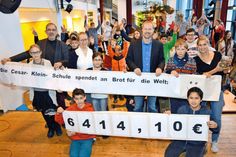 Vor ihren Mitschülern enthüllen Leslie (v.l.), Maxi, Lydia, Tim und Bryan mit Schulleiter Georg Krauß (hinten l.), den Lehrkräften Juliane Bremer und Christin Tiedemann sowie Torsten Nolte von „Brot für die Welt“ die Plakate mit der stolzen Spendensumme. (Foto: Stefan Setje-Eilers)