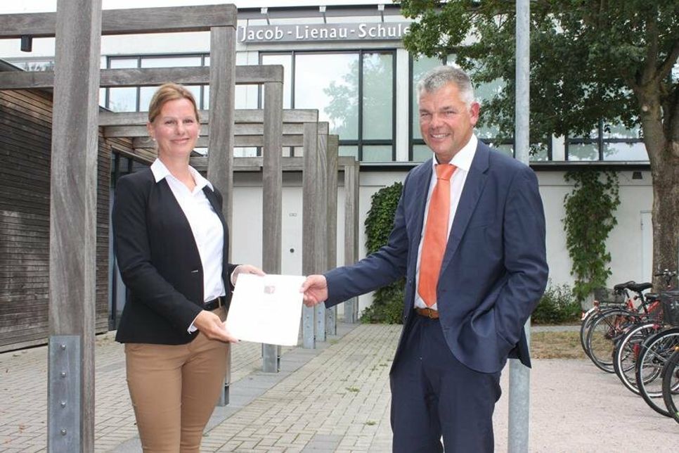 Yvonne Pohle mit der Ernennungsurkunde von Schulrat Thomas Panten.