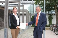 Yvonne Pohle mit der Ernennungsurkunde von Schulrat Thomas Panten.