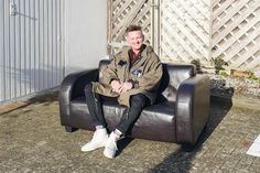 Schlagerstar Ben Zucker auf dem Ledersofa, das in seinem aktuellen Musikvideo zu sehen ist und jetzt für den guten Zwecks versteigert wird.