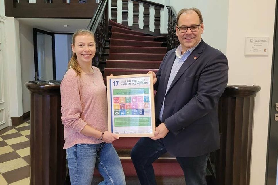 Bürgermeister Mirko Spieckermann und Nachhaltigkeitsmanagerin Lina Koop präsentieren die Urkunde.