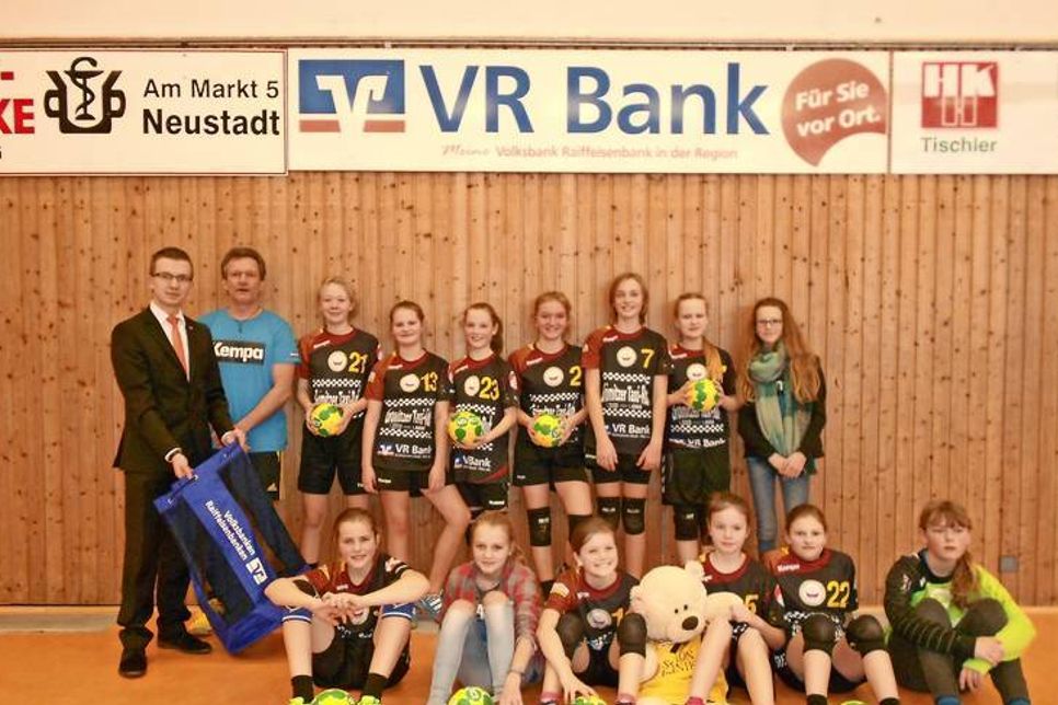 Ole Sawtschin (lks.), Kundenberater der VR Bank in Neustadt, übergab die Handbälle an die weibliche D-Jugend der HSG Ostsee.