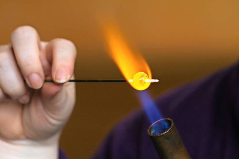 Glasperlen aus farbigen Muranoglas vor der offenen Flamme
