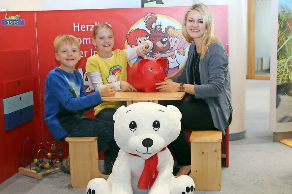 So wie Sparkassen-Mitarbeiterin Judith Hoppe und die fleißigen Sparer Elena und Enrico freuen sich schon viele Kinder auf den Weltspartag bei der Sparkasse Holstein.