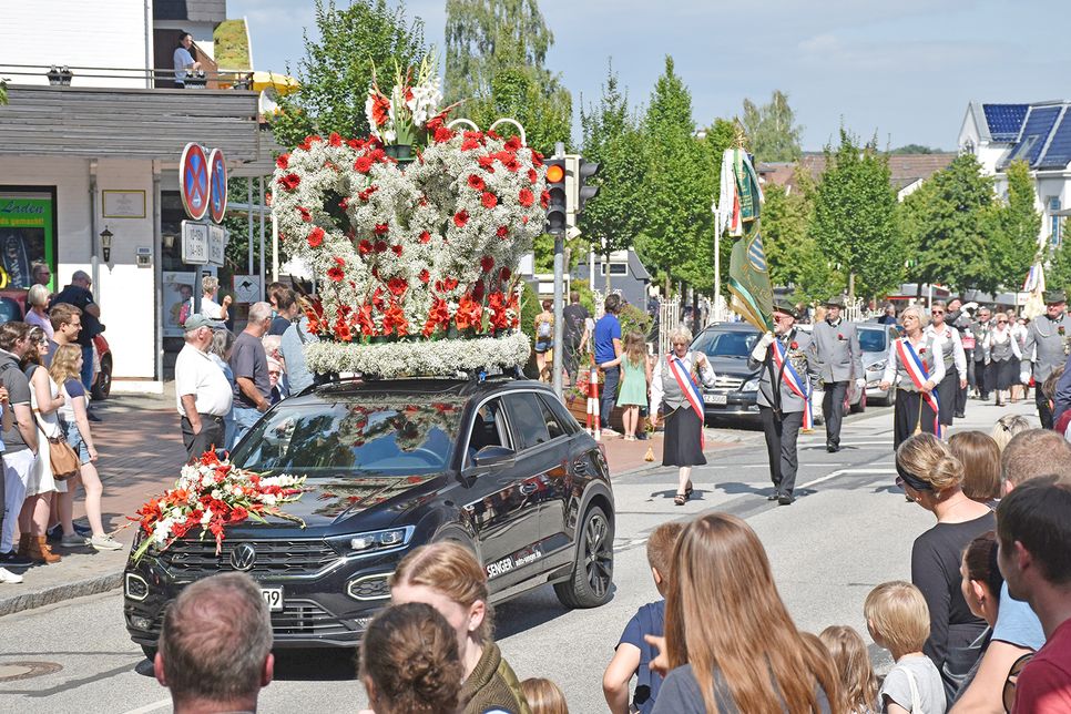 Auch das hat Tradition: Vorweg fährt ein Fahrzeug, das eine riesige Blumenkrone durch die Straßen chauffiert.