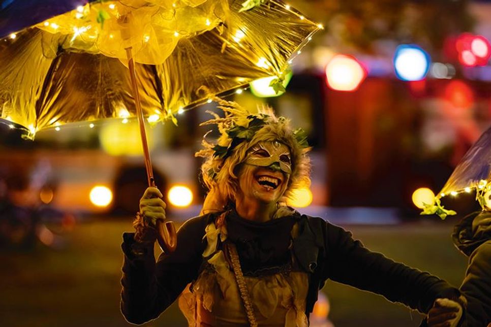 Auch Fabelwesen feiern mit, wie hier eine tanzende Fee mit beleuchtetem Schirm.