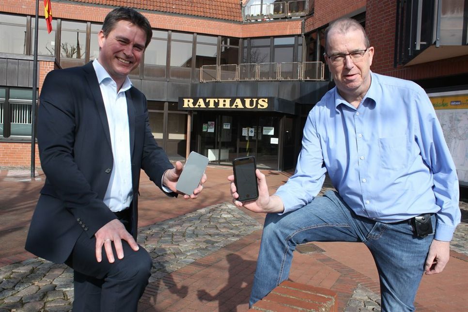 Bürgermeister Michael Robien (lks.) und Fachbereichsleiter Finanzen Michael Bendt präsentieren die neue App.