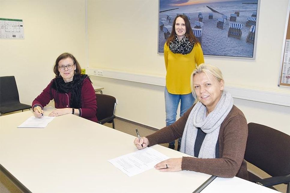 Die Schulleiterinnen Dr. Cordula Braun (OGT, links) und Esther Passig (GGS-Strand) unterzeichnen vor den Augen von Katrin Alpers, stv. Fachdienstleitung, die erneuerte Kooperationsvereinbarung zwischen den beiden Timmendorfer Schulen.