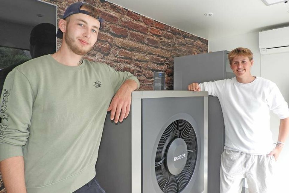 Levin Möller und Chris Hundertmark an der Innen- und Außeneinheit einer Wärmepumpe
