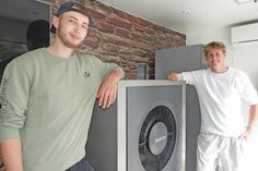 Levin Möller und Chris Hundertmark an der Innen- und Außeneinheit einer Wärmepumpe