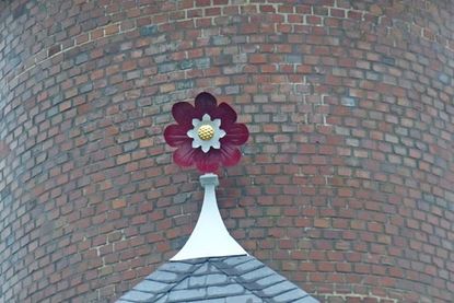 Auf dem Dachvorsprung glänzt die kleine metallene Rose wieder in ihrem alten Glanz.