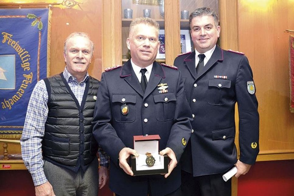 Der zum Oberlöschmeister beförderte Burkhard Wegener (Mitte) wurde zum &amp;quot;Feuerwehrmann des Jahres&amp;quot; gekürt und erhielt aus den Händen von Juwelier Mike Lindner eine wertvolle Uhr. Ortswehrführer Björn Jessen (rechts) freut sich mit ihm. (Foto: René Kleinschmidt)