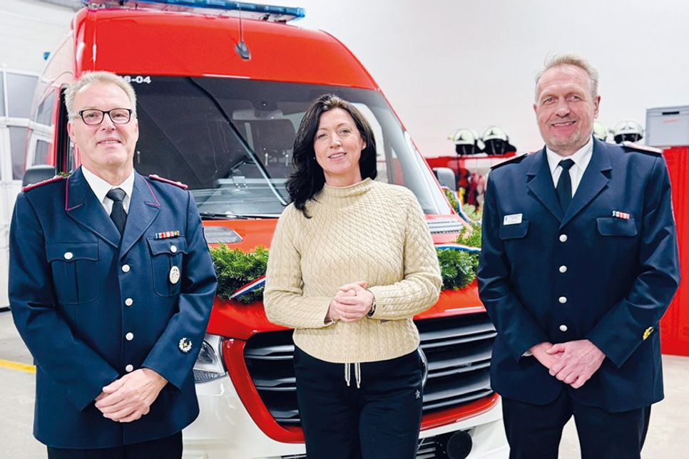 Ortswehrführer Jürgen Kraemer (von links), Bürgermeisterin Bettina Schäfer und der stellvertretende Kreiswehrführer Lars Wellmann vor dem neuen Mannschaftstransportwagen.