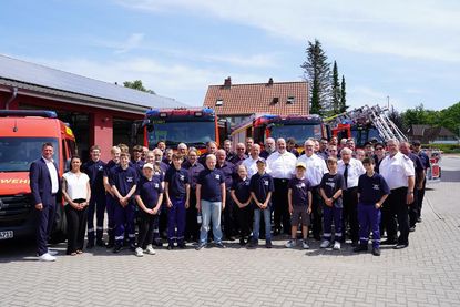 Die Lensahner Wehr mit Bürgermeister Michael Robien (lks.) und Sina Bumann aus dem Fachbereich Bauleitplanung und Brandschutz des Amtes Lensahn (2. v. lks.) vor den neuen Fahrzeugen.