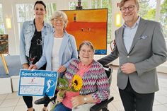 Silke Szymoniak von der TSNT GmbH (links) freut sich mit Bürgermeister Sven Partheil-Böhnke über die Spende, die Heidi Döring (im Rollstuhl) an Barbara Bergmann (Kinderherz e.V.) überreichen konnte.
