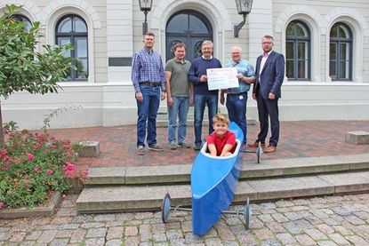 Seifenkisten-Rennfahrer Alexander Jubel, Christian Kahl und Peter Jubel von der Bürgergemeinschaft Oldenburg, Siegmar Witzleben sowie Uwe Wolters vom Automobil-Club Oldenburg e.V. im ADAC und Oldenburgs 1. Stadtrat Jens Junkersdorf haben sich am Donnerstag zur symbolischen Spendenübergabe vor dem Oldenburger Rathaus versammelt.
