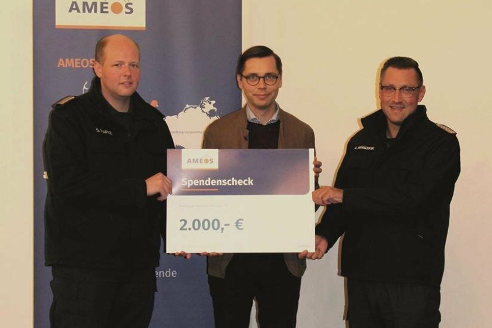 Stadtwehrführer Alexander Wengelewski (re.) und sein Stellvertreter Sebastian Papke (lks.) nehmen den symbolischen Scheck vom Regionalgeschäftsführer Ameos Nord, Stephan Freitag (Mitte), entgegen.