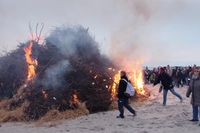 Gemeinsames Entzünden des Feuers mit Fackeln.