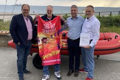 Rettungsschwimmer Klaus Stüllenberg (2. v. lks.) erhielt eine Ehrenurkunde für 35 Jahre Wachdienst auf der DLRG Wachstation Pelzerhaken.